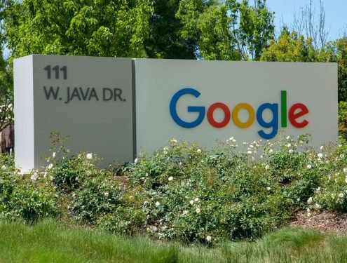 a google sign in front of some bushes and trees